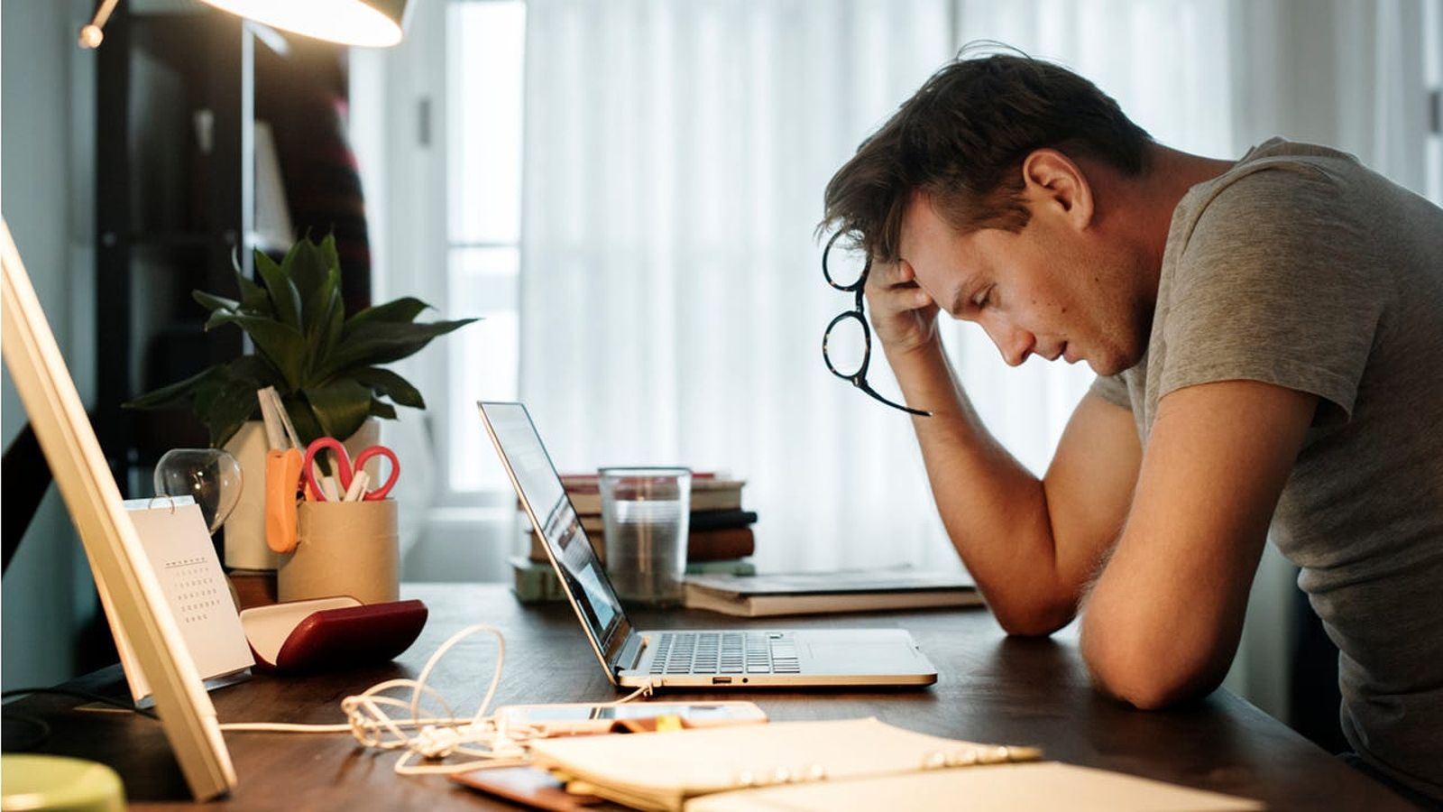 Stressed man looks at laptop